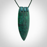 This is a handcrafted aotea stone rei puta pendant.